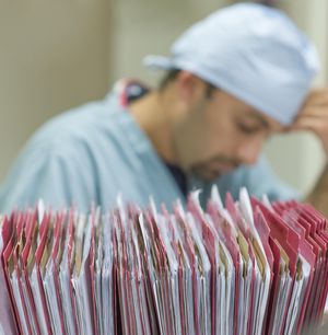 Nurse with patient files in foreground