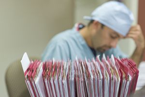 Nurse with patient files in foreground